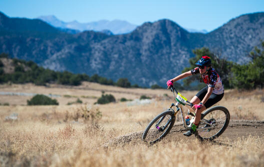 Girl riding mountain bike on a dusty curve
